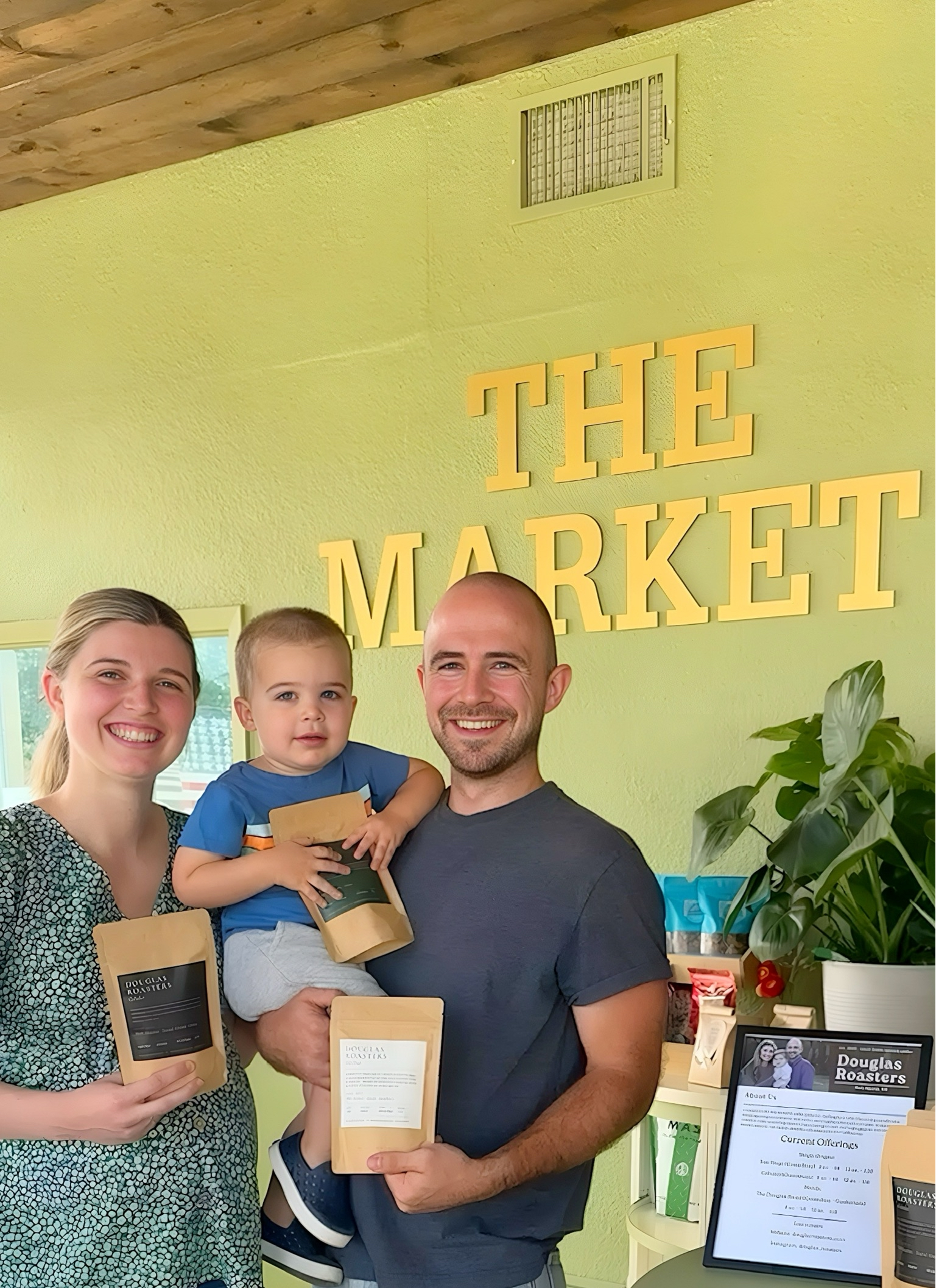 Joe, Emma, and son at The Market with Douglas Roasters coffee bags